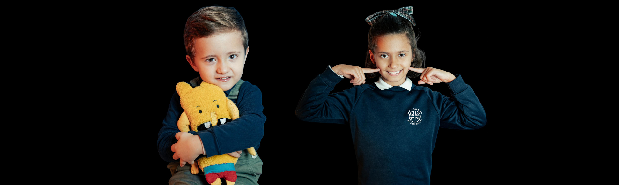Niños sonrientes con juguete y uniforme escolar
